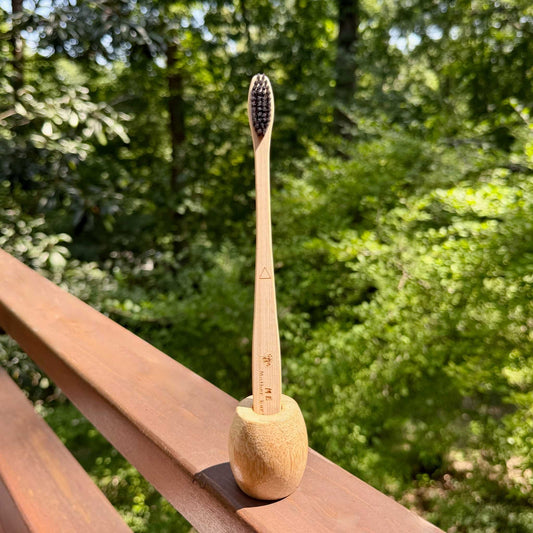 Me Mother Earth bamboo charcoal toothbrush standing in bamboo holder