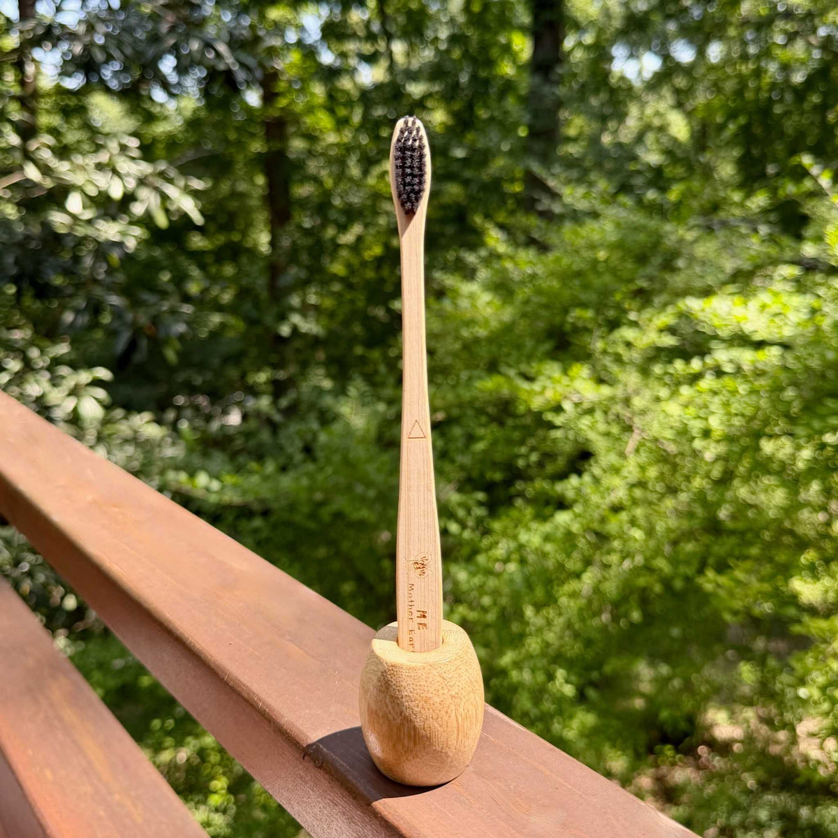 Me Mother Earth bamboo charcoal toothbrush standing in bamboo holder