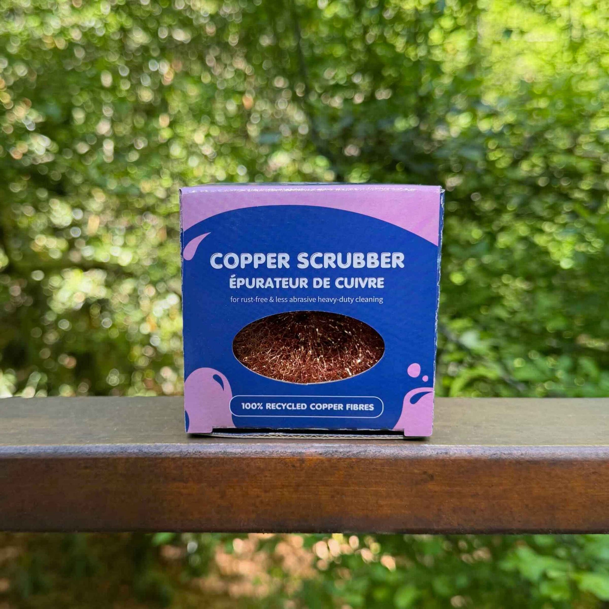 copper pot scrubber in box with trees in background