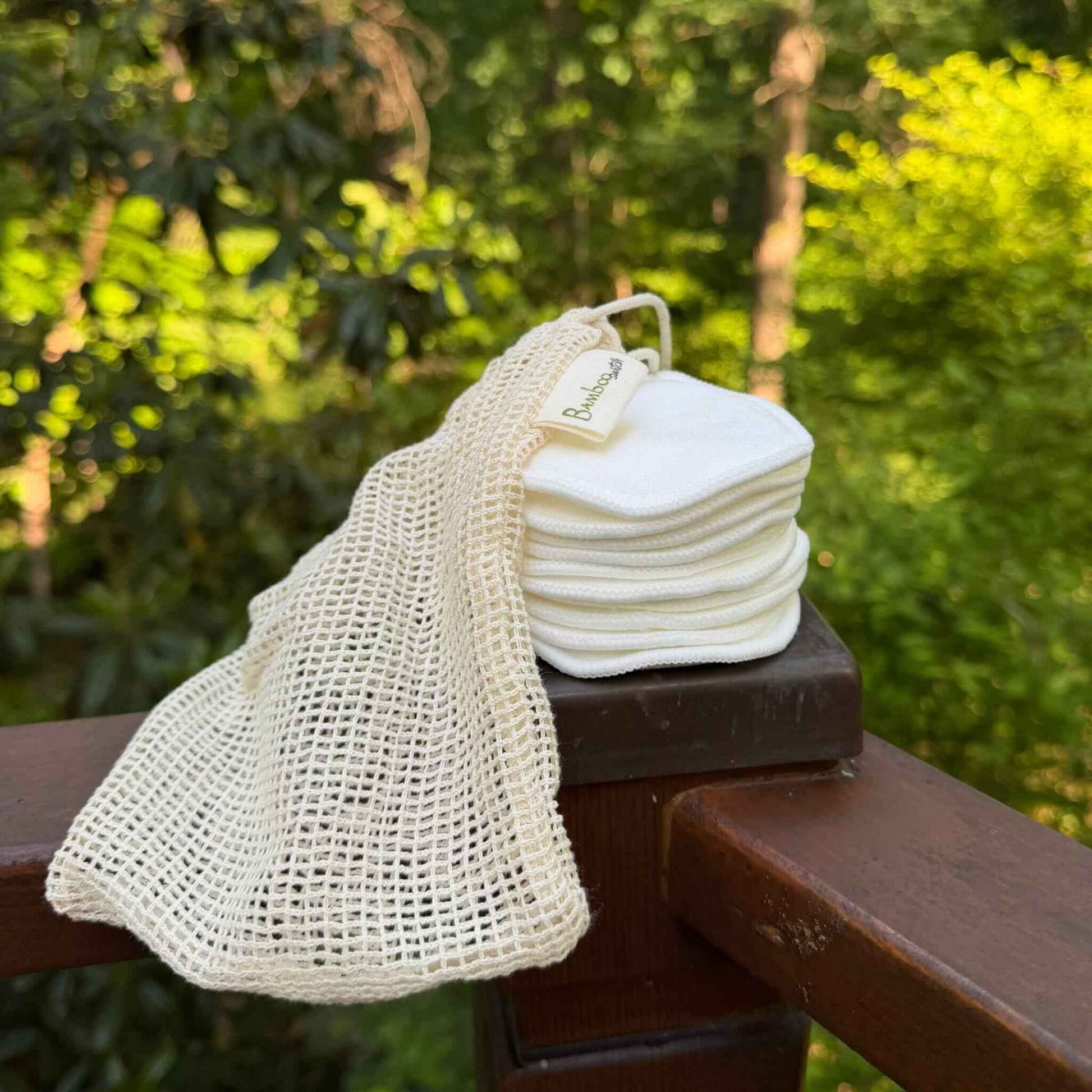 stack of white cotton rounds draped by a mesh bag
