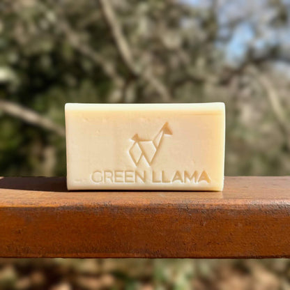 Unscented zero-waste dish soap bar on a a wooden surface with a blurred natural background - 6 oz vegan dish washing bar by Green Llama