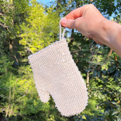 Natural sisal exfoliating shower glove held by its cotton loop