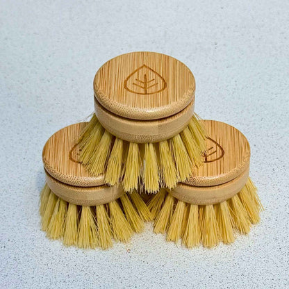 Three stacked replacement dish brush heads with bamboo tops and sisal bristles